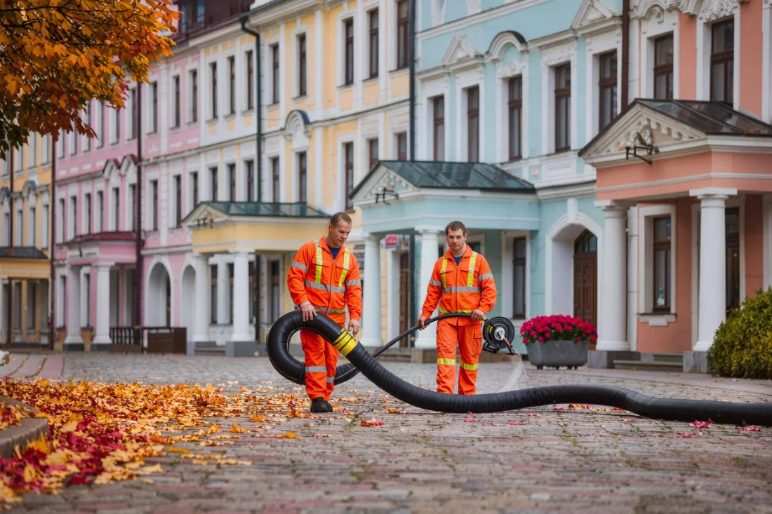 Technici s hadicí v lázeňské ulici s historickými fasádami